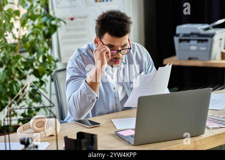 Handsome man analyzes important documents while concentrating at a modern desk during the day. Stock Photo