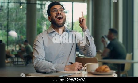 Pensive man Indian Arabian businessman male freelancer worker thoughtful student think plan create study write notebook in cafe pondering business guy Stock Photo