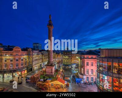 View at dusk at Christmas time looking across Grey's Monument in Newcastle upon Tyne towards the christmas market with christmas lights Stock Photo