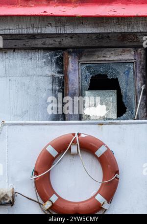 Lifebelt on boat, ship with broken window Stock Photo