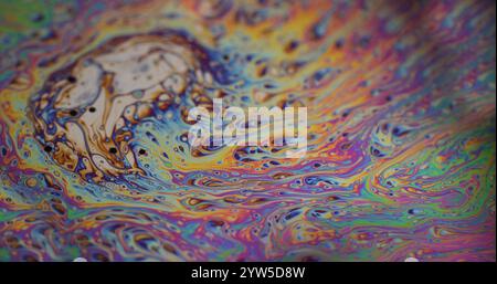 Abstract dispersion. Light liquid foam. Defocused multicolor purple green oil paint curve acrylic slick on dark black blurred art background. Stock Photo