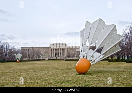 One of four giant shuttlecocks on the grounds of the Nelson Adkins Museum of Art overlook the Kansas City, Missouri skyline. Stock Photo
