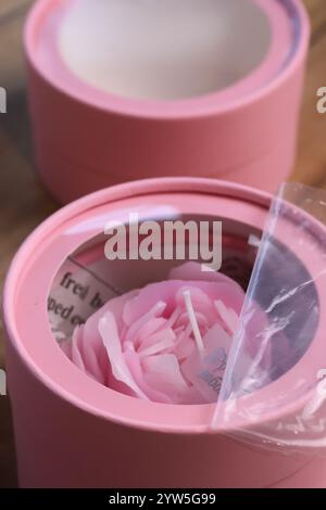 A flower-shaped candle in a mini box with a window in the lid. Gift packaging. Close-up. Stock Photo