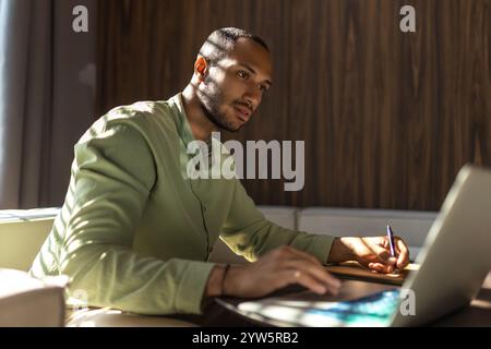 Confident man using laptop while working in office Stock Photo