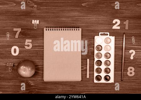 School supplies, office supplies on a dark wood background. Demonstrating color of 2025 year mocha mousse Stock Photo
