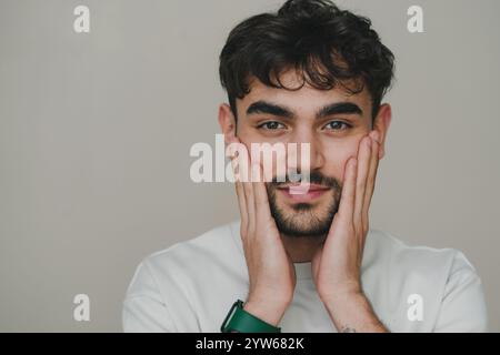 A vibrant portrait of a Young Man with curly hair, joyfully expressing his happiness and charm Stock Photo