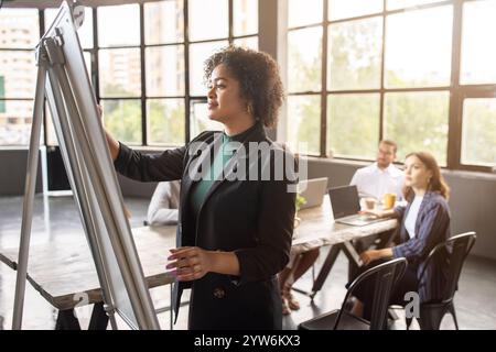 Team collaborates in modern office setting with diverse professionals Stock Photo