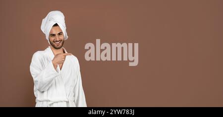 Young man in a bathrobe showing excitement in an indoor setting Stock Photo