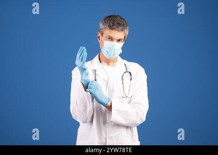 Mature European doctor preparing to examine a patient in healthcare setting Stock Photo