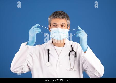 European doctor preparing to put on a face mask in a healthcare setting Stock Photo