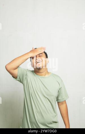 Asian man with glasses holding forehead feeling dizzy isolated on white background Stock Photo
