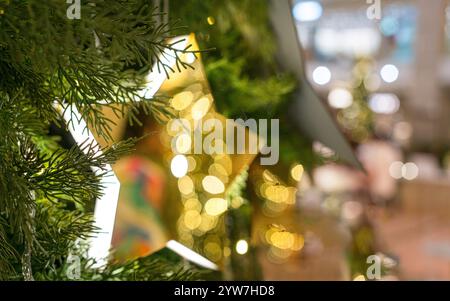 Beautiful colorful star decor hanging on Christmas tree. Bokeh lights, festive hoiday concept. Stock Photo
