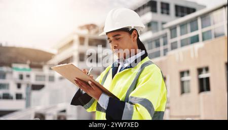 Woman, engineer and clipboard in city for checklist, inspection notes and safety compliance. Supervisor, writing and outdoor with documents for urban Stock Photo