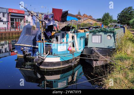Colourful canal boats, barges, with rotary clothes line and mirror reflections on River Lee Navigation at Stratford, London, England, UK Stock Photo