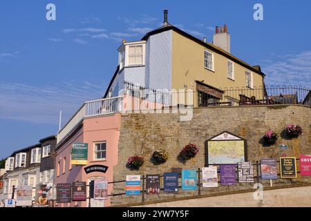 Lyme Regis: Lyme Regis: Pastel colour Georgian buildings and advertisements at Cobb Gate, Lyme Regis on the Devon Dorset border, England Stock Photo