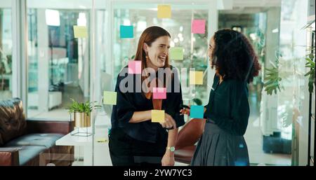 Business women, laughing and chatting with funny joke, conversation or talk for social or break at office. Female people, employees or colleagues with Stock Photo