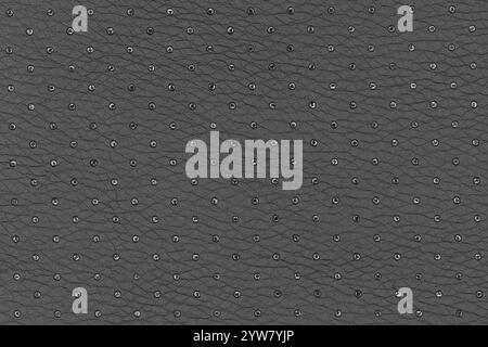 Black color abstract artificial leather with small dots and holes pattern for background. Closeup top view of pebble colour surface level background Stock Photo