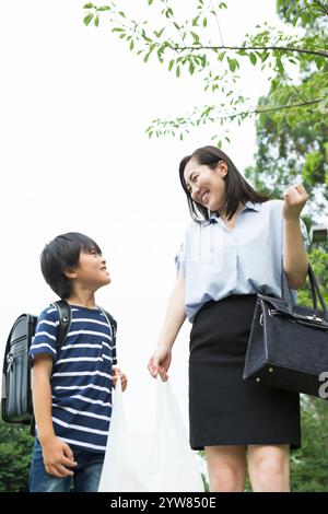 Smiling parent and child talking while carrying shopping bags together Stock Photo
