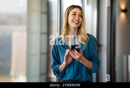 Young happy elegant busy professional business woman, manager using cell phone in office. Success Stock Photo