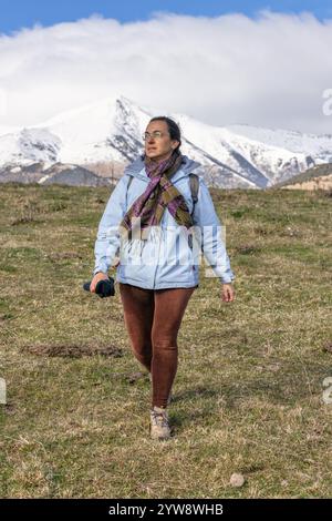 Middle aged spanish tourist woman walking on the Pyrenees mountain at winter time in a sunny day Stock Photo