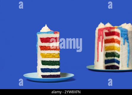 Slice of buttercream layered cake with multicolored batter, minimalist on a blue table Stock Photo
