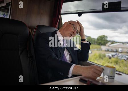 John Swinney, First Minister of Scotland and leader of the Scottish National Party, out canvassing across Scotland, driving on his battle bus from Inverness to Nairn, in Inverness, Scotland, on 2 July 2024. Stock Photo