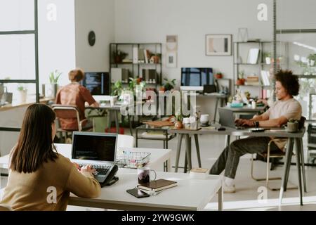 Young adult team working in modern office, they sitting at work desk with computers and programming Stock Photo
