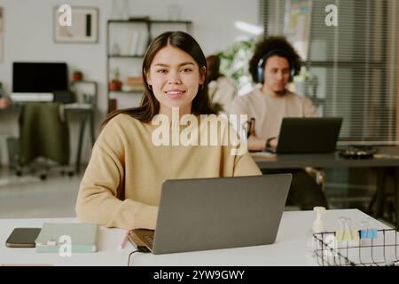 Medium close up portrait of young adult office working in laptop in office Stock Photo