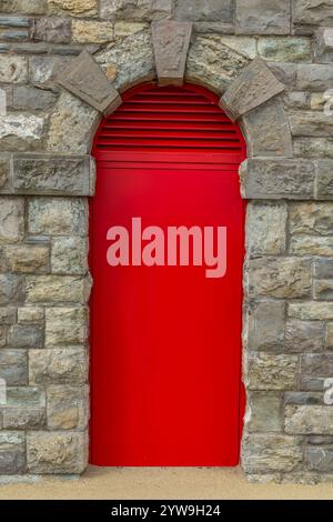 Red door in an old, brick wall Stock Photo