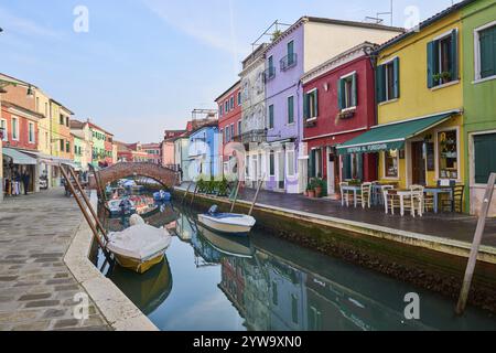 Colorful houses and a bridge 'Ponte - Fondamenta San Mauro' going over the waterway with boats lying in the water on the island of Burano, Italy, Euro Stock Photo