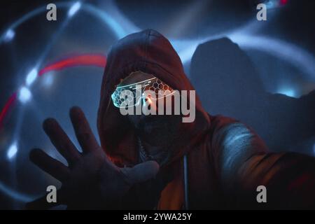 Cyberpunk man with glowing glasses uses augmented reality in futuristic technological environment Stock Photo