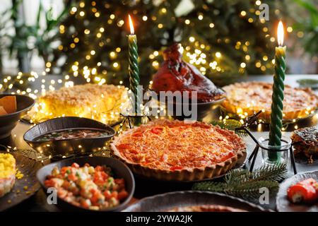 Festive table setting with Christmas decorations and burning candles in the dining room, cozy romantic Christmas in the evening atmosphere Stock Photo