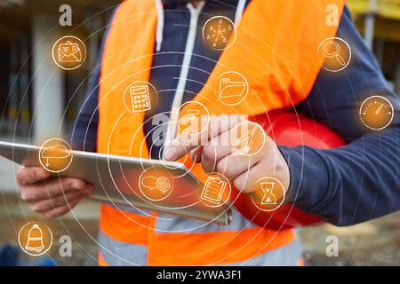 Hand of foreman operating touchscreen on tablet computer with icons as concept for digital planning Stock Photo