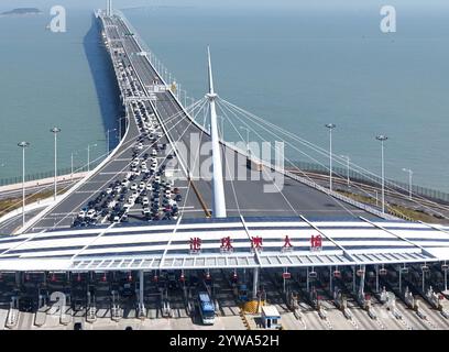 (241210) -- GUANGZHOU, Dec. 10, 2024 (Xinhua) -- An aerial drone photo taken on Feb. 12, 2024 shows vehicles on the Hong Kong-Zhuhai-Macao Bridge in south China. In recent years, the construction of cross-river and cross-sea passages in the Guangdong-Hong Kong-Macao Greater Bay Area has developed rapidly. The passage networks play a significant role in building and improving the comprehensive three-dimensional transportation network in the Greater Bay Area, as well as promoting deeper integration and development in the region. (Xinhua) Stock Photo