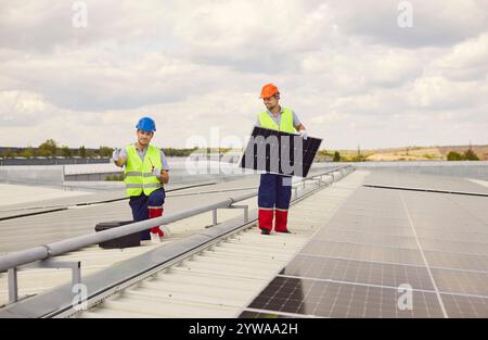 Workers Installing And Maintaining Solar Panels On Roof For Renewable Energy Stock Photo