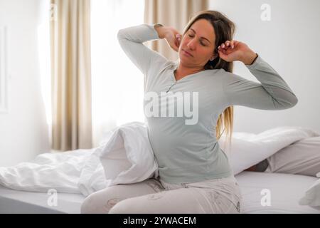Young couple is sleeping in bed. Woman is waking up for work. Stock Photo