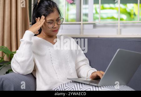 Woman working from home and have stress from work, Women working about new startup on laptop to analysis finance of project in outside office, Woman w Stock Photo