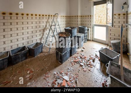 Kitchen undergoing renovation with construction debris and buckets scattered on the floor Stock Photo