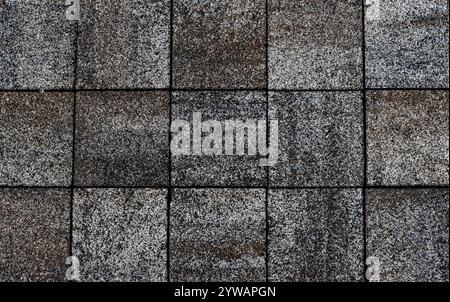 A gray and brown tile floor with a black border. The tiles are square and are arranged in a grid Stock Photo