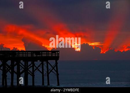 Isle Of Palms, United States. 10th Dec, 2024. Dawn breaks behind heavy clouds as a front pushes through the low country causing crepuscular rays to radiate outwards as the sun rises over the Atlantic Ocean along Front Beach, December 10, 2024 in Isle of Palms, South Carolina. The warm and humid weather will give way to a cold front later in the week. Credit: Richard Ellis/Richard Ellis/Alamy Live News Stock Photo