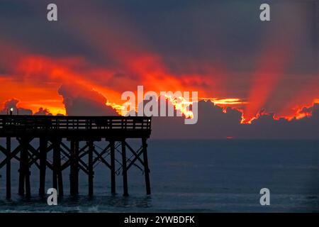 Isle Of Palms, United States. 10th Dec, 2024. Dawn breaks behind heavy clouds as a front pushes through the low country causing crepuscular rays to radiate outwards as the sun rises over the Atlantic Ocean along Front Beach, December 10, 2024 in Isle of Palms, South Carolina. The warm and humid weather will give way to a cold front later in the week. Credit: Richard Ellis/Richard Ellis/Alamy Live News Stock Photo