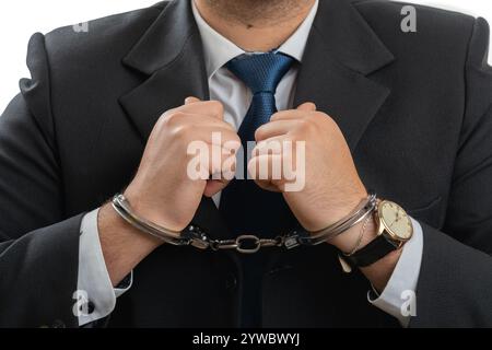Close-up of handcuffs on adult businessman wearing office casual suit attested for corruption as illegal concept isolated on white background Stock Photo