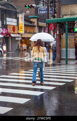 Elderly Japanese women wearing kimonos in the rain on Shijo Street in downtown Gion, Kyoto, Japan Stock Photo