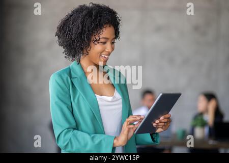 Diverse team collaborates in modern office space using digital devices Stock Photo