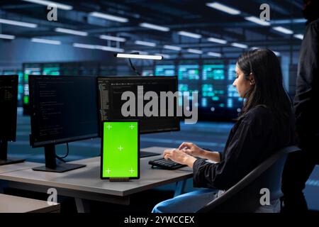 Admin in server hub uses isolated screen device to find firewall misconfigurations affecting performance. Woman checking systems bottlenecks leading to sluggish data transfer rates using mockup tablet Stock Photo