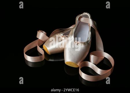 Pair of beautiful pointe shoes on black mirror surface Stock Photo