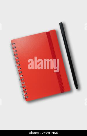 red notebook with pencil. school notebook on cyan background, spiral notepad on table Stock Photo