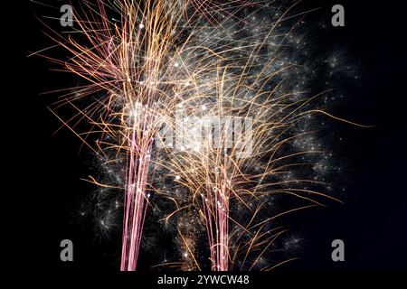 Fireworks in black sky, funfair fete exhibition, family fun holiday vacation celebration, bright loud pyrotechnics firecrackers explosion Stock Photo