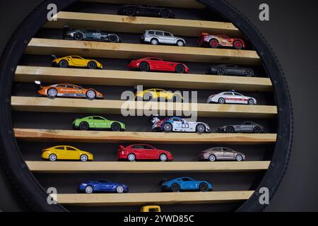 Toy cars collection on a display shelf in several rows. miniature vehicles, car models Stock Photo