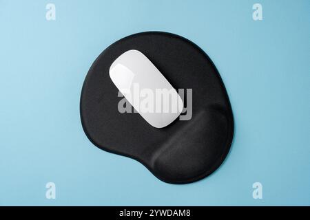 Top view of modern white mouse on black mousepad on blue table Stock Photo